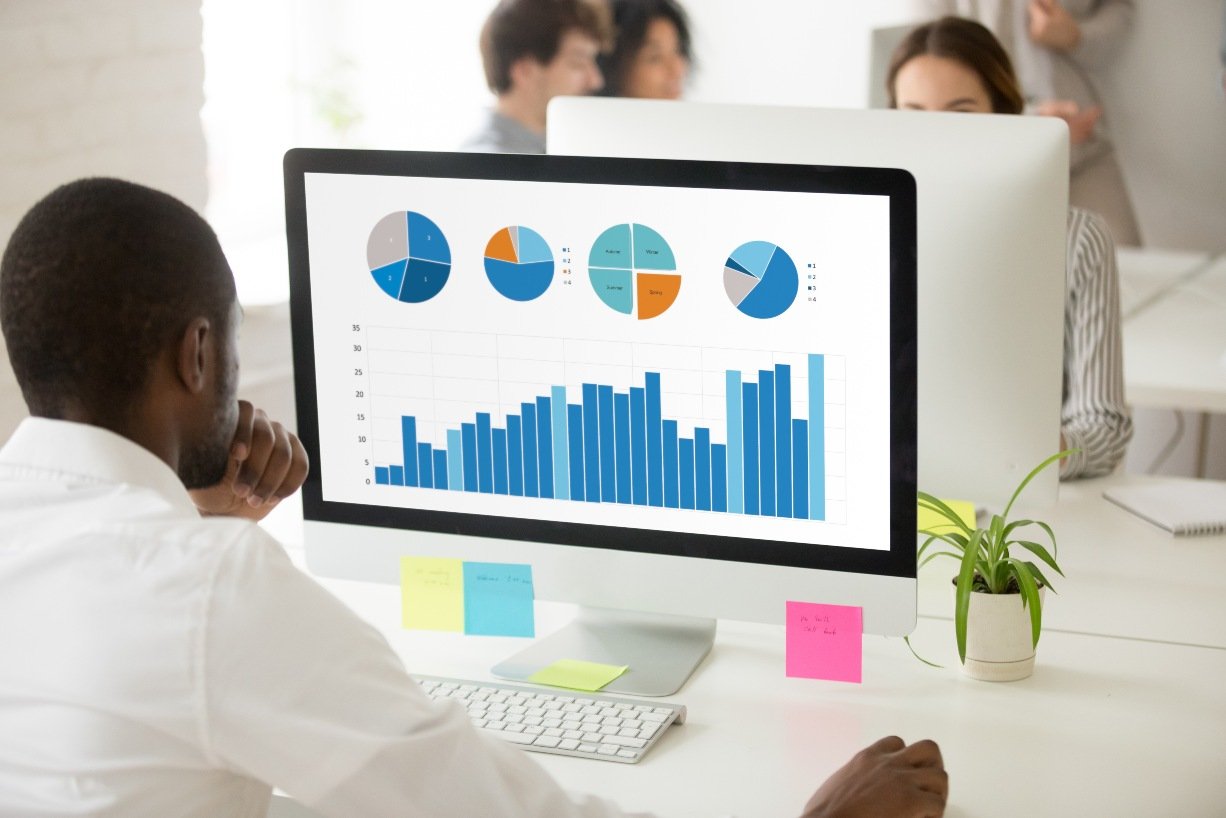 Black-employee-analyzing-graphic-data-preparing-statistical-report-on-pc
