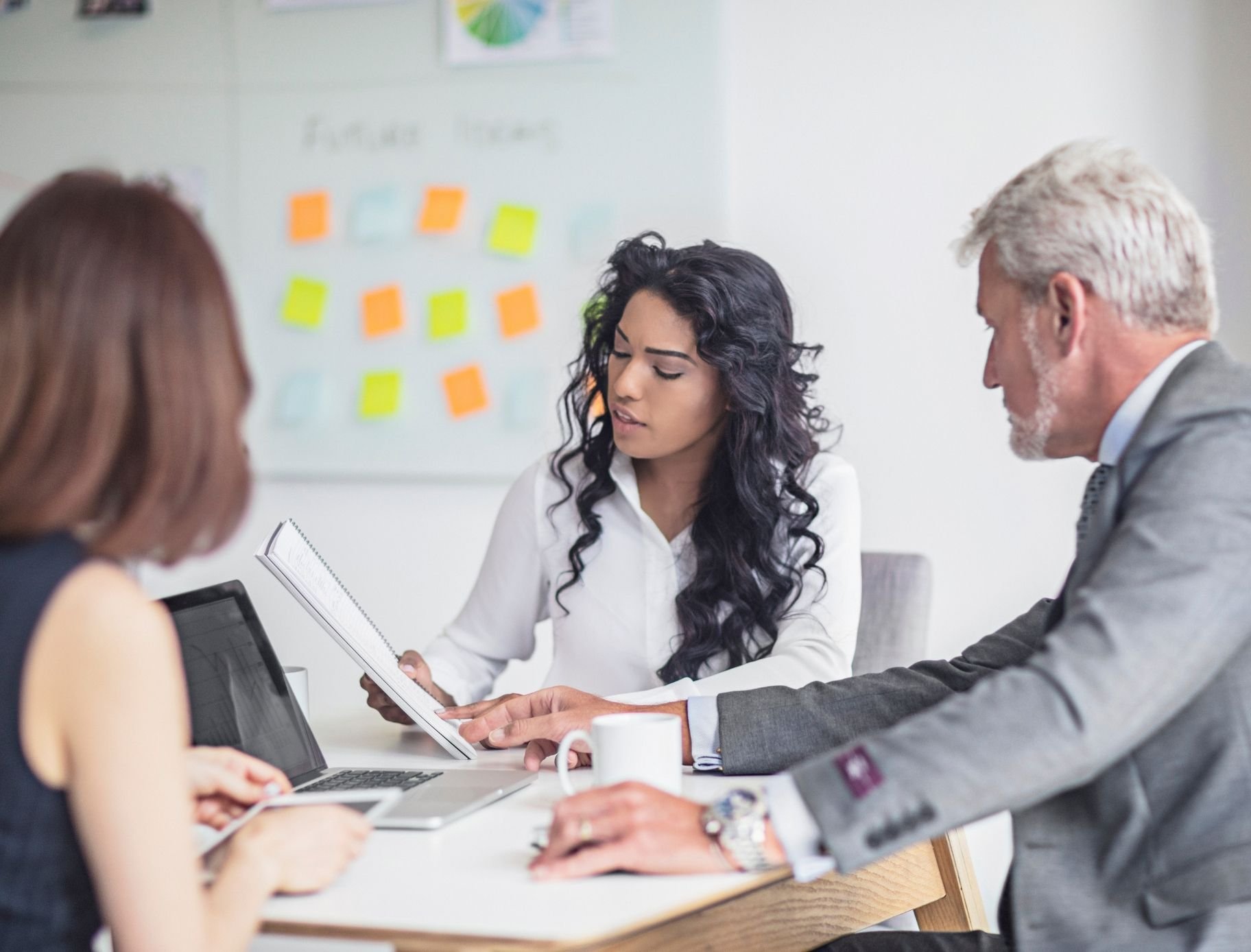 Businesswoman-showing-document-to-coworkers-698652832