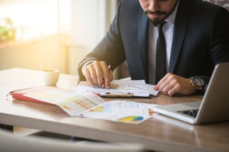 Young-businessman-showing-graphs-by-pen-690566584_5760x3840